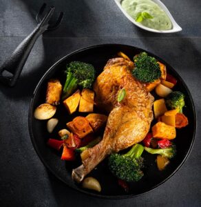 Baked chicken legs with rainbow vegetables and avocado
